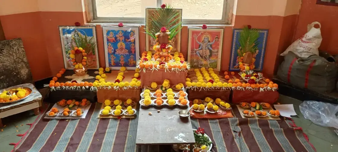 Festival puja platform with marigold garlands and bowls of prasad offerings