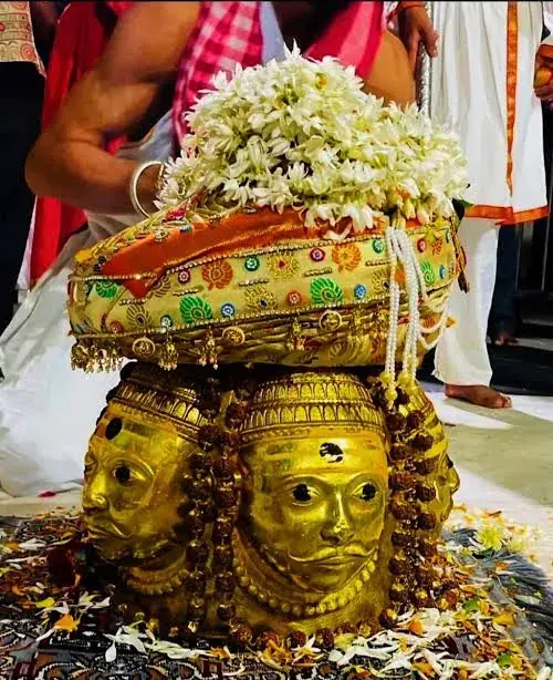 Golden multi-faced Shiva idol with Rudraksha beads and white flower offering